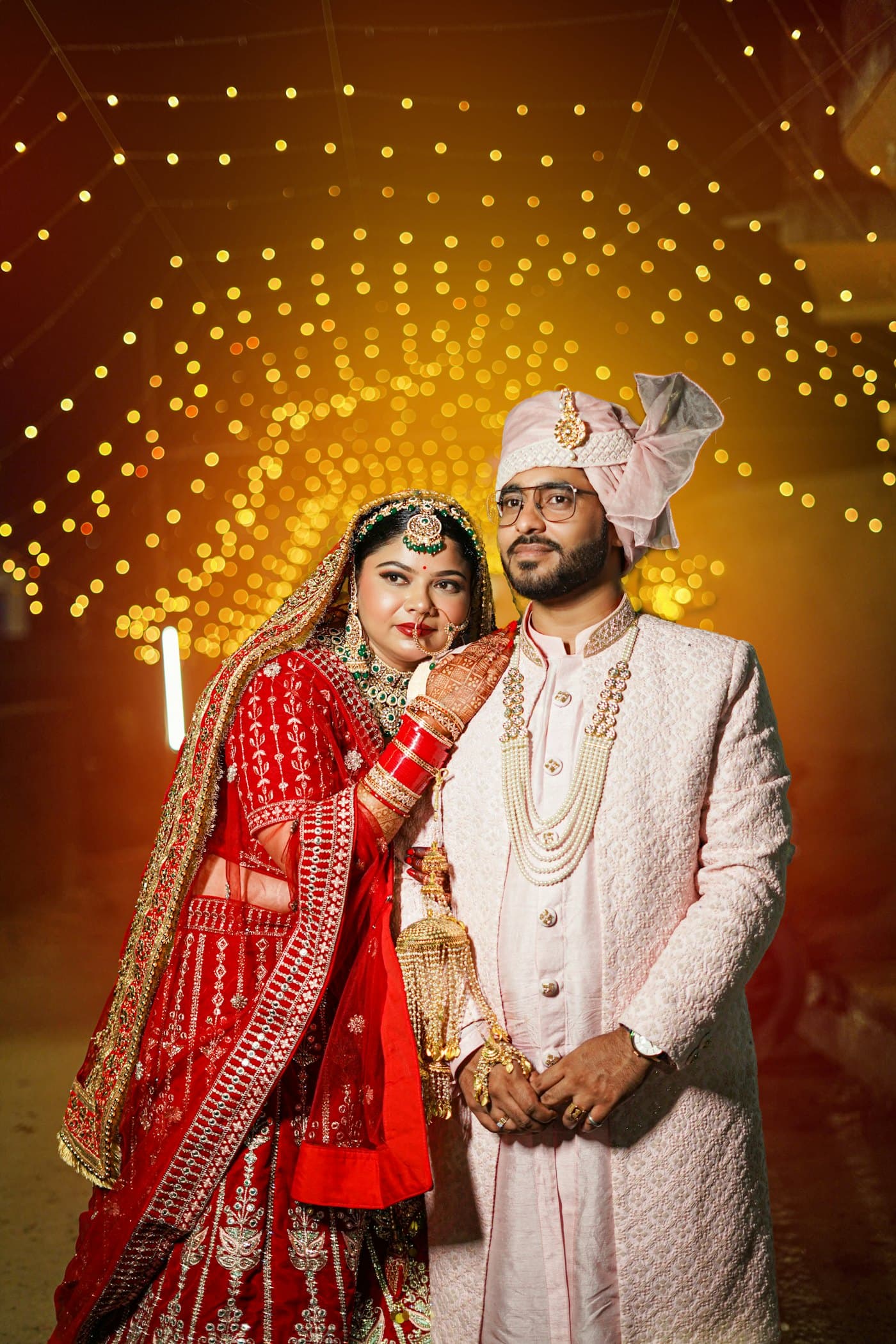 A bride and groom posing together at night