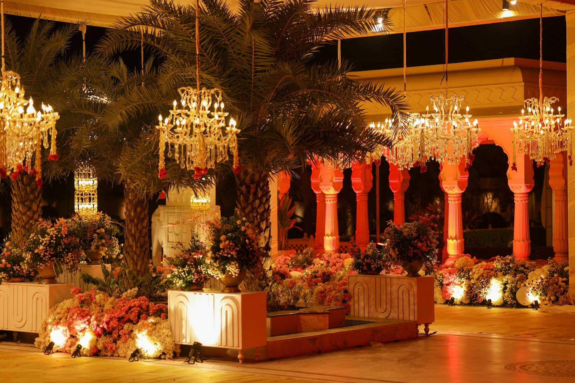 An indoor function hall with chandeliers and floral arrangements