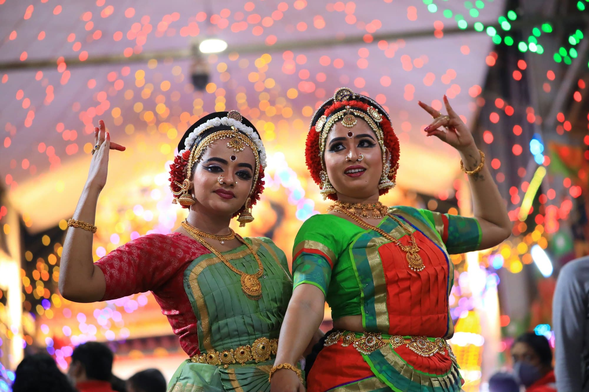 Two women in traditional Indian dress dancing together