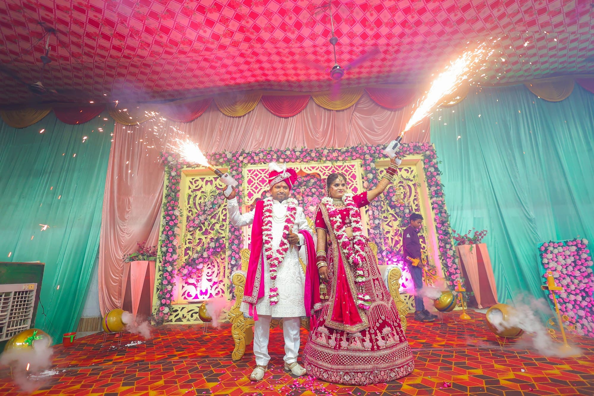 A bride and groom holding sparklers at a night wedding